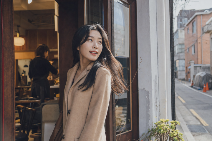 A candid Korean woman leaving a neighborhood hair salon