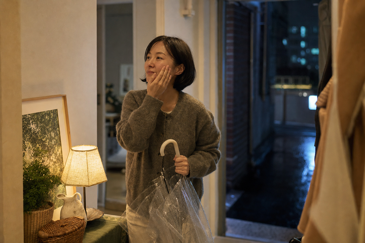 A candid Korean woman coming home on a rainy Seoul evening