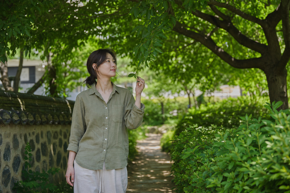 A candid Korean woman walking through a lush Seoul garden