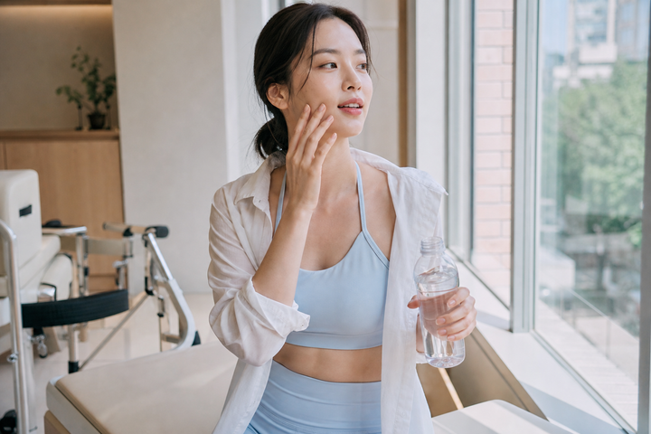 A candid Korean woman cooling down after a morning Pilates class