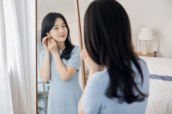 A candid Korean woman preparing for a friend's wedding