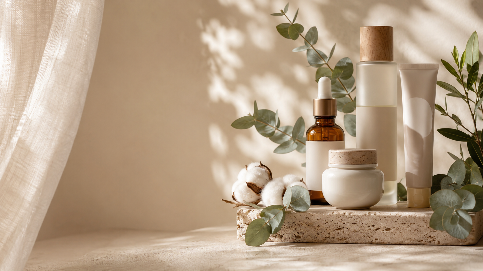 Korean skincare products on a travertine pedestal with eucalyptus